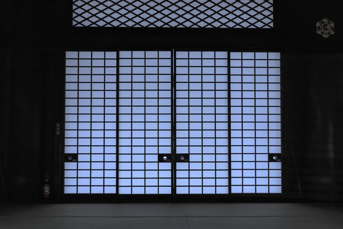 Portes shoji translucides laissent passer une lumière bleue dans une pièce sombre Portes shoji translucides laissent passer une lumière bleue dans une pièce sombre